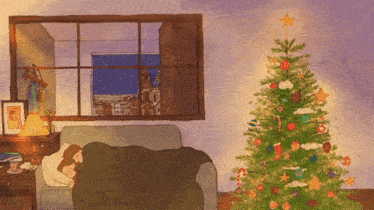 a couple laying on a couch with a christmas tree in front of them