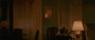a man is on fire in a living room with a lamp