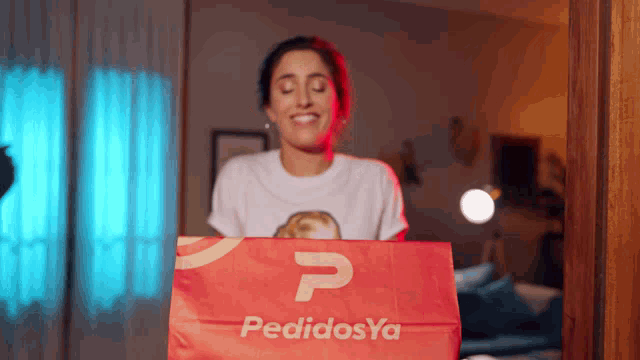a woman is holding a bag that says pedidosya
