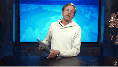 a man stands in front of a screen that says ' nbc ' on it