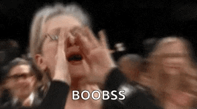 a woman is covering her face with her hands while screaming in a crowd .