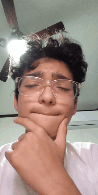 a young man wearing glasses is making a face