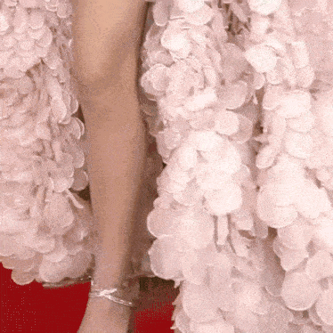 a close up of a woman 's leg wearing a pink dress