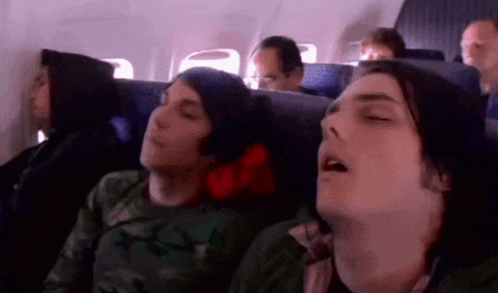 a group of people sleeping on a plane with their eyes closed