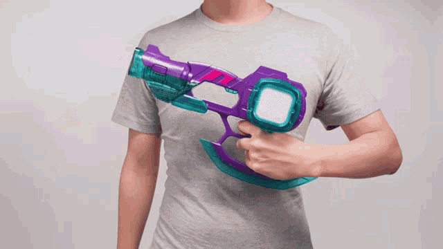 a man holding a purple and blue toy gun