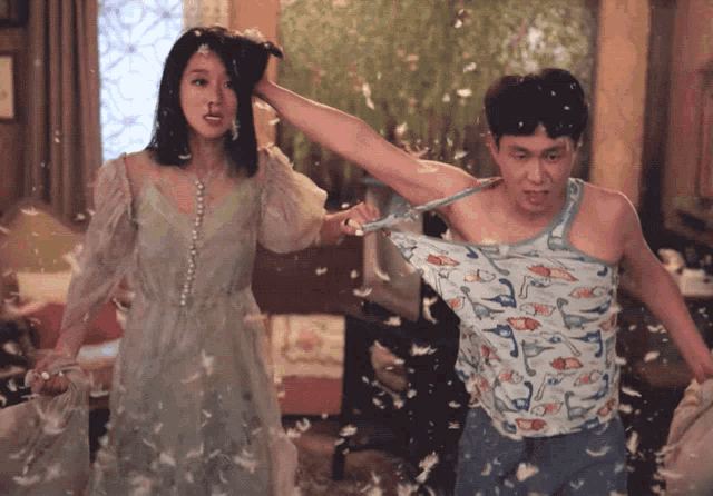 a man in a tank top with ducks on it is being thrown by a woman in a dress