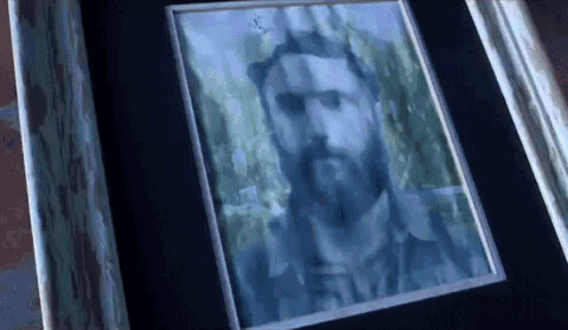 a painting of a man with a beard in a blue frame .