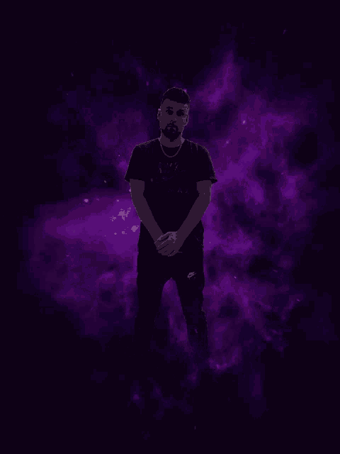 a man wearing a black nike shirt stands in front of a purple background