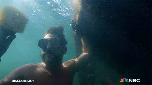 a man is swimming in the ocean with the nbc logo in the corner