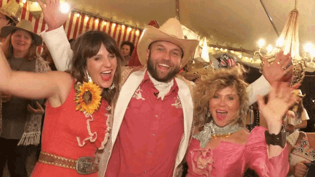 a man in a cowboy hat and a woman in a pink dress pose for a picture