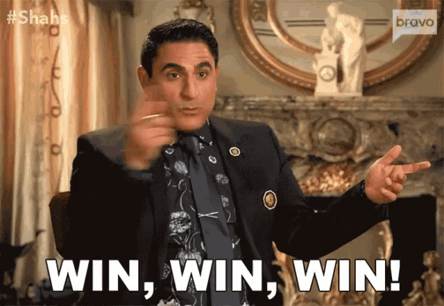a man in a suit and tie is pointing and saying win , win , win !