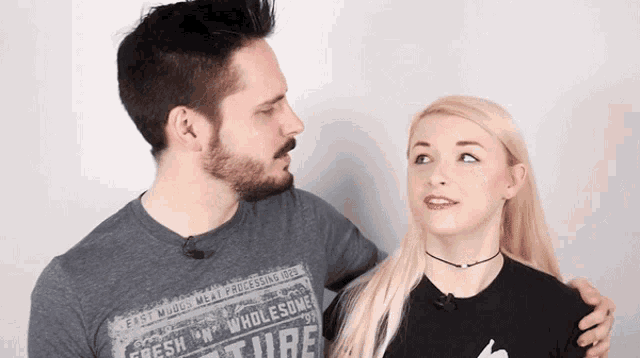 a man and a woman are looking at each other and the man is wearing a shirt that says fresh wholesome