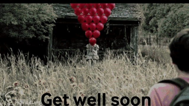a person holding a bunch of red balloons in front of a building with the words " get well soon " on the bottom