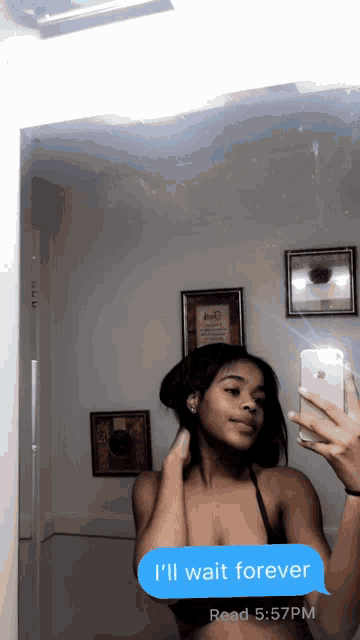 a woman is taking a selfie in front of a mirror with a text message that says i 'll wait forever