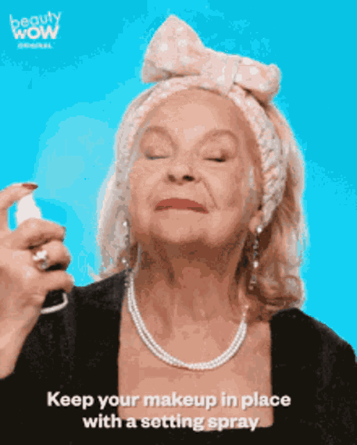 a woman spraying a setting spray on her face