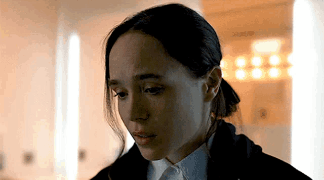 a close up of a woman 's face with a ponytail .