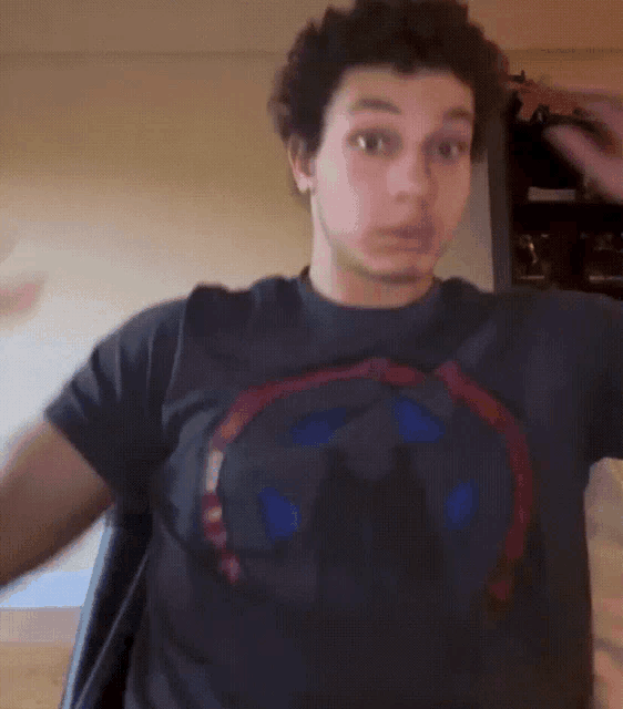a young man wearing a black t-shirt with a captain america logo on it