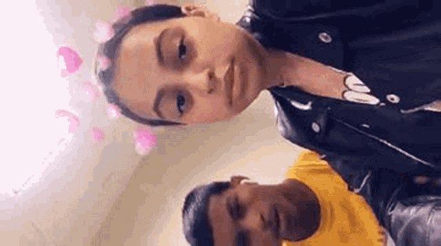 a man and a woman are standing next to each other and looking at the camera .