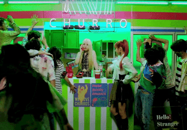 a woman is standing in front of a churro stand talking on a cell phone .