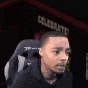 a man is sitting in a gaming chair in front of a sign that says celebrate !