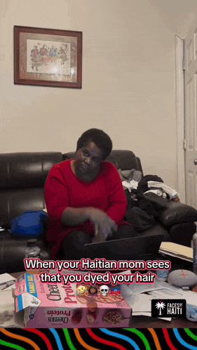 a woman sits on a couch with a box of cheerios