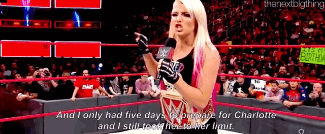 a woman in a wrestling ring is talking into a microphone