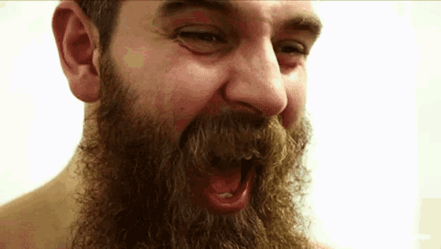 a man with a beard and mustache is making a funny face .