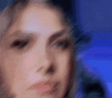 a close up of a woman 's face with a blue background