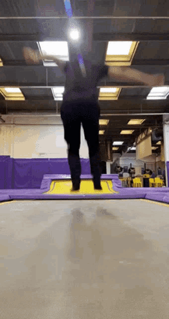 a person is jumping on a purple trampoline