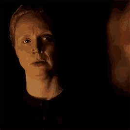 a close up of a woman 's face in the dark with a shadow on her face .