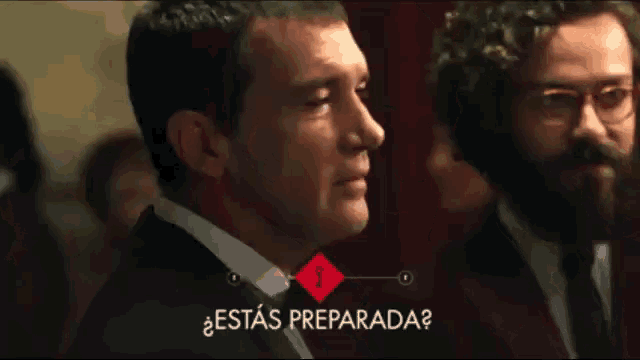a man in a suit and tie stands in front of a sign that says " esta preparada "