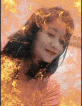 a woman 's face is surrounded by flames and smoke