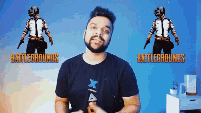 a man stands in front of a blue wall with battlegrounds written on it