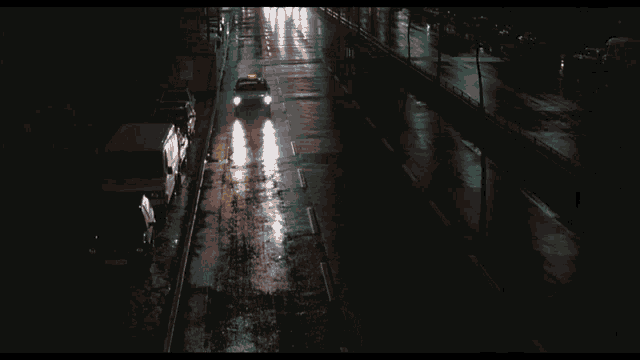a car with a yellow light on the top of it is driving down a wet road
