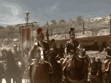 a group of roman soldiers riding horses with a banner that has the letter e on it