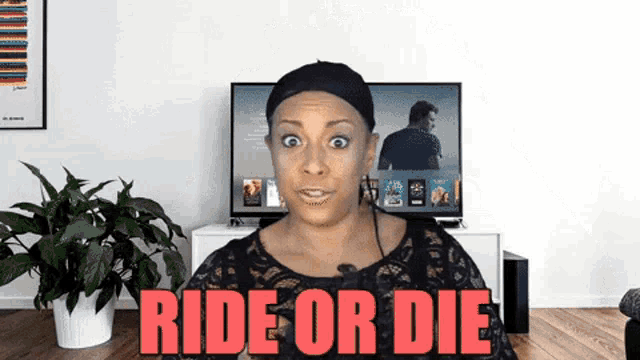 a woman sitting in front of a tv with the words ride or die above her