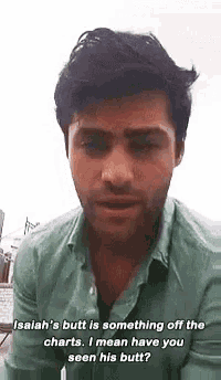 a man with a beard and a green shirt is talking to another man .