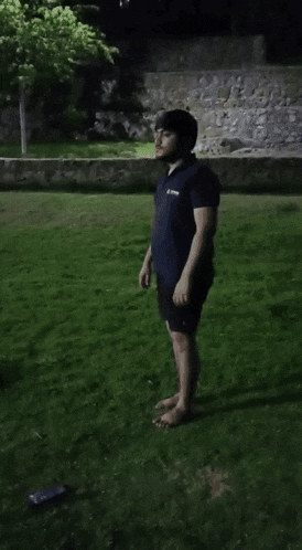 a man wearing a blue shirt that says asics on it