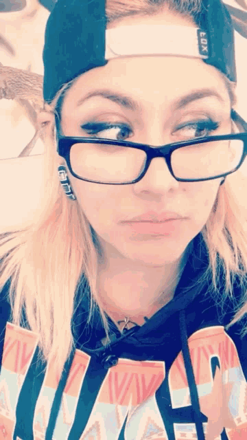a woman wearing glasses and a baseball cap with the word fox on it