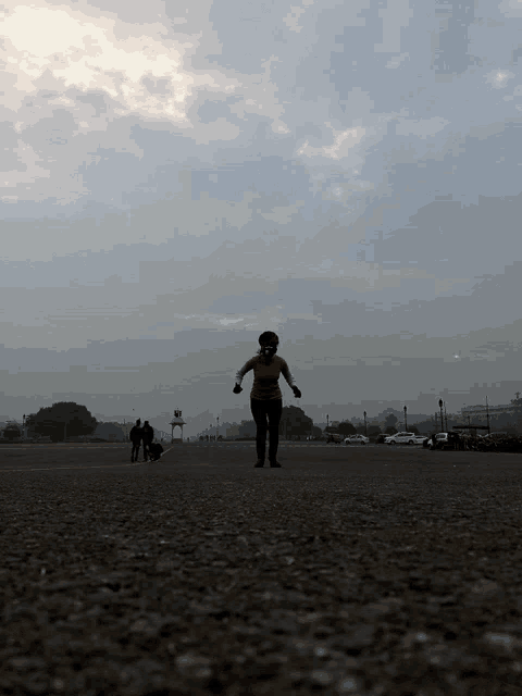 a person walking on a gravel road with a gray sky in the background