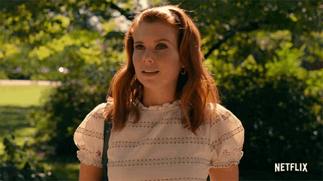 a woman in a white top is standing in a park with a netflix logo in the corner