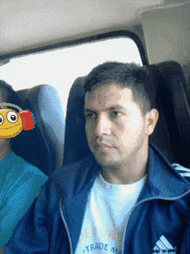 a man wearing a blue adidas jacket sits next to a woman wearing headphones