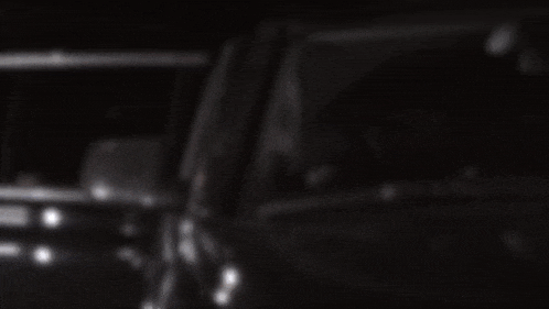 a blurry photo of a car driving down a street at night