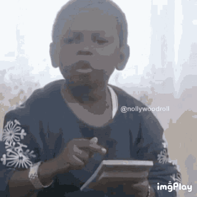 a young boy is holding a calculator and a piece of paper .