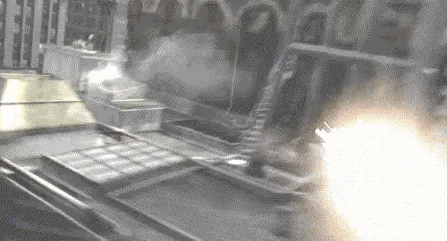 a black and white photo of a machine with smoke coming out of it and a fire coming out of it .