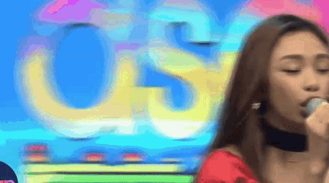 a woman is singing into a microphone in front of a sign that says usc