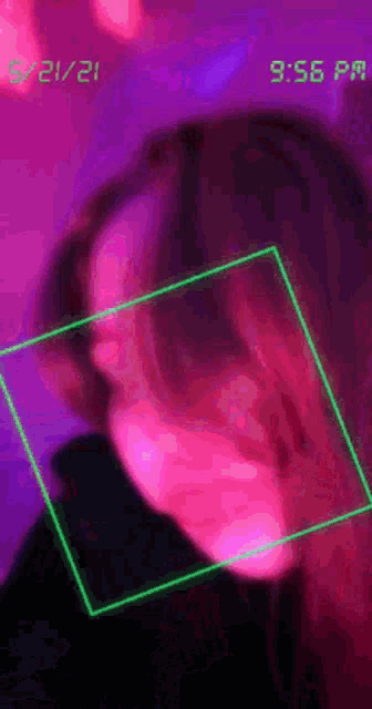 a blurry picture of a person 's face with a green frame around it and a purple background .