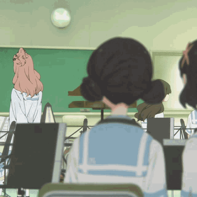 a group of girls are sitting in a classroom with a clock on the wall above them that says 3:00