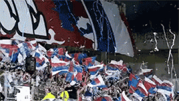 a bunch of confetti is being thrown at a crowd of people