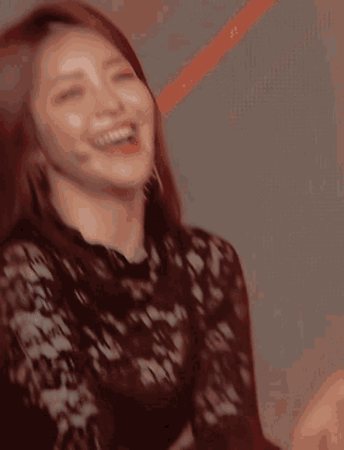a woman wearing a black lace top is laughing